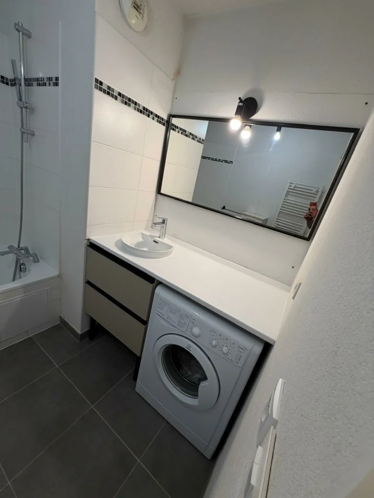 Rénovation de salle de bain à Bordeaux avec meuble vasque, machine à laver intégrée et grand miroir