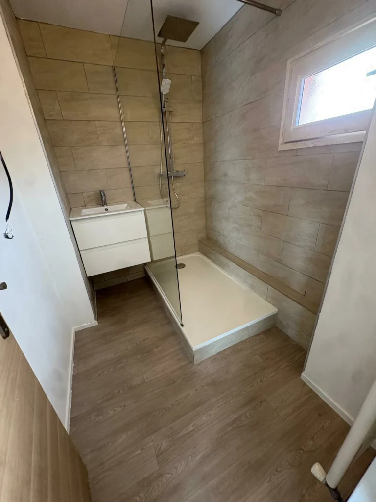 Rénovation de douche italienne beige à Bordeaux avec paroi vitrée et meuble vasque moderne